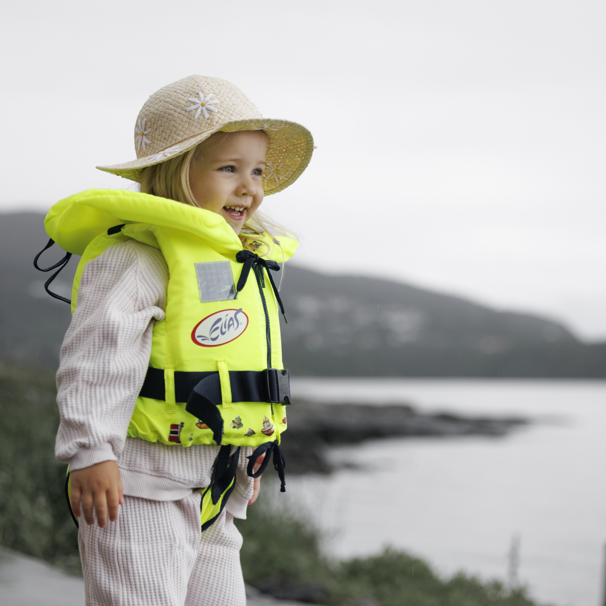 En jente står ved vannkanten, iført Soft Elias barnevest fra Regatta