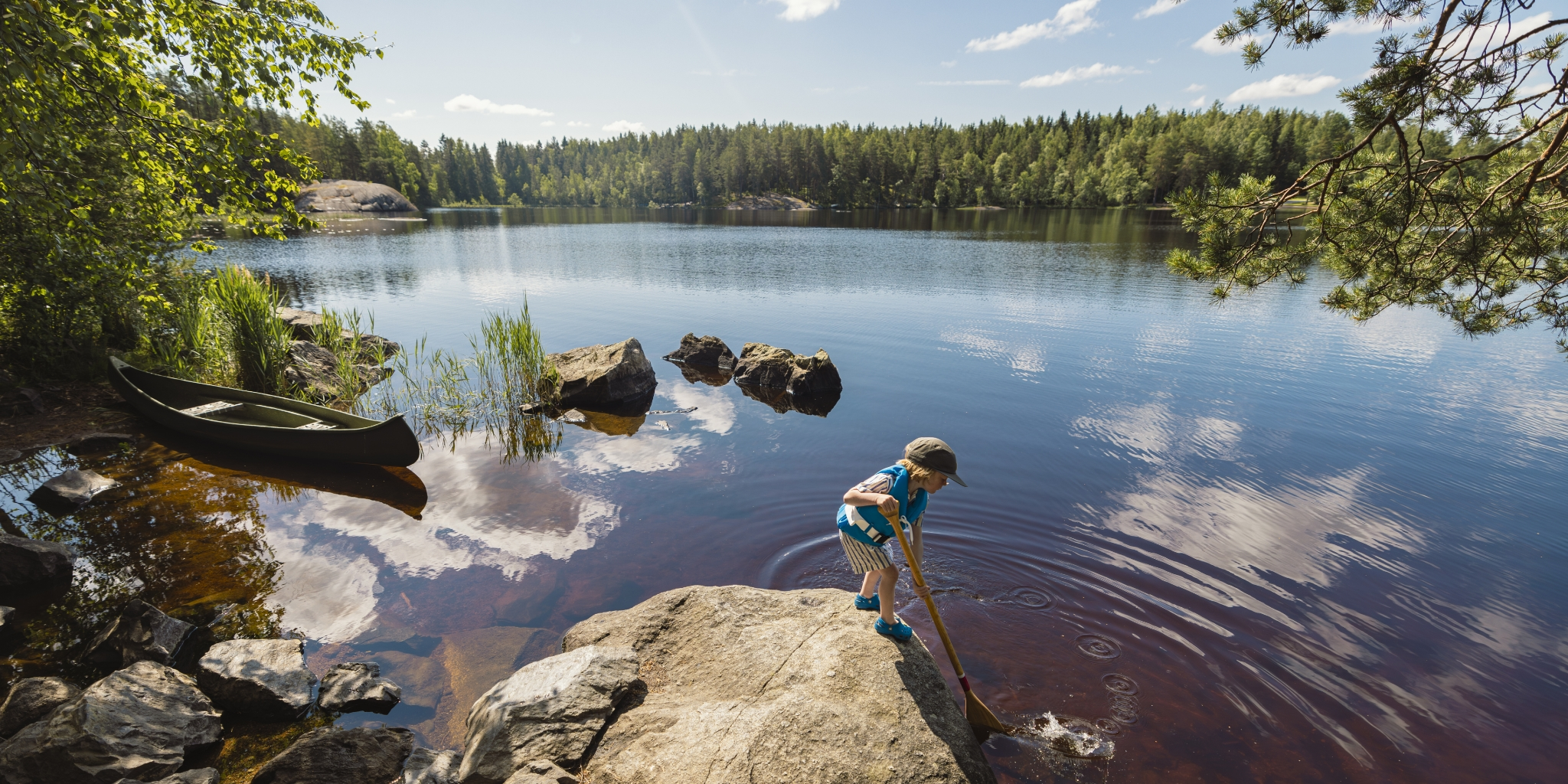 En gutt har på seg flytevest fra Regatta når han leker i vannkanten