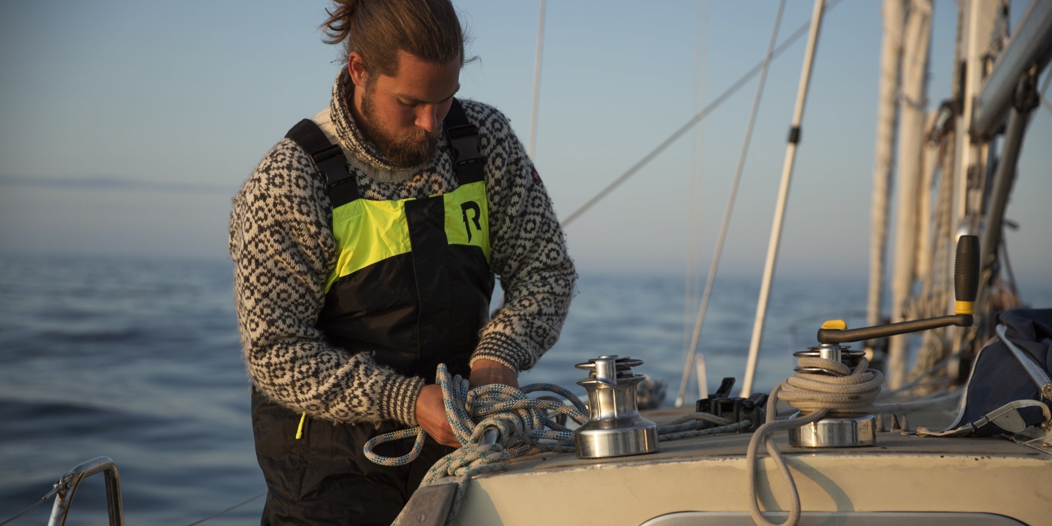 En person har på seg flytebukse fra Regatta på dekk på seilbåt